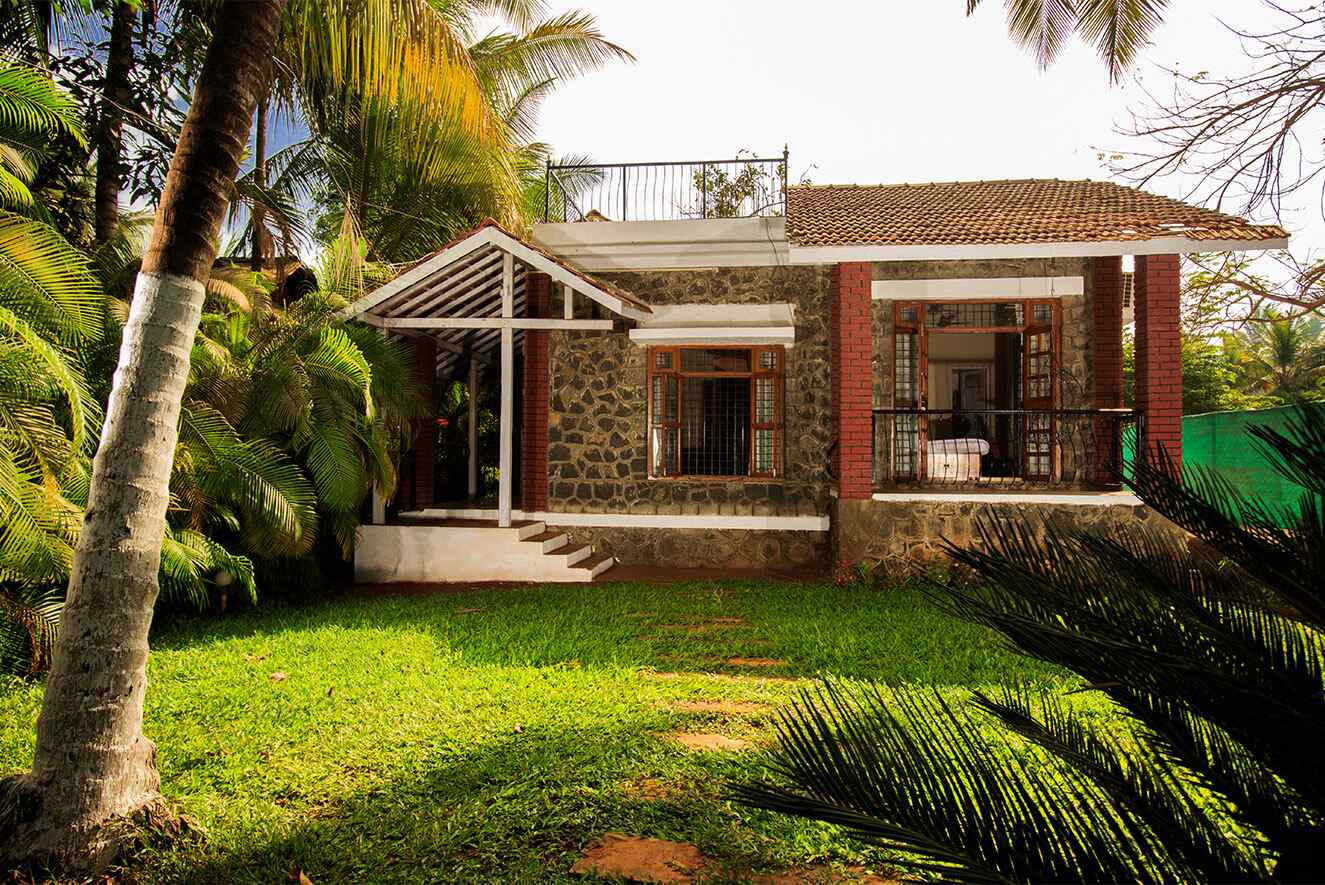 Sidz Cottage Alibaug, Exterior look of the farmhouse, surrounded by trees. 